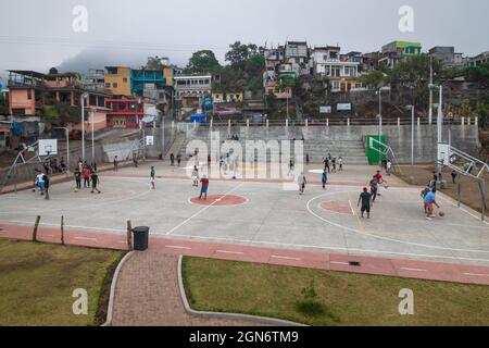Santiago Atitlan, Guatemala - 29 March 2018: Local men playing football and basketball on the sports field along the rustic town houses