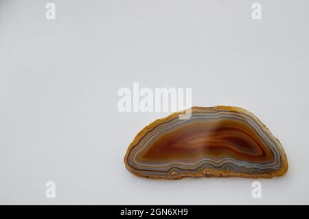 Amazing red Agate Crystal cross section isolated on white background. Natural translucent agate gemstone surface, Blue abstract structure slice mineral stone macro closeup with copy space  Stock Photo