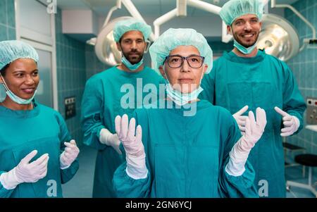 Successful team of surgeon standing in operating room, ready to work on a patient Stock Photo