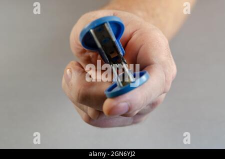 Hand reaches into the camera Staple remover. Clerical device for Stock Photo