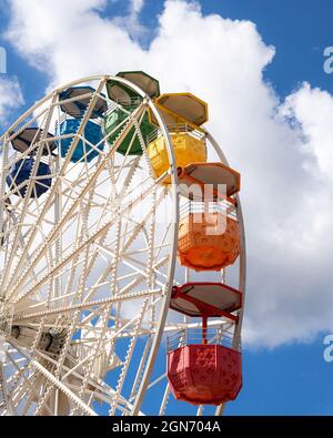Colorful ferris wheel on a shiny day with some clouds in the background Stock Photo