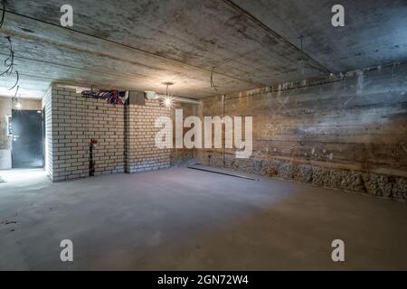 Empty basement room with minimal preparatory repairs in interior with white brick walls Stock Photo