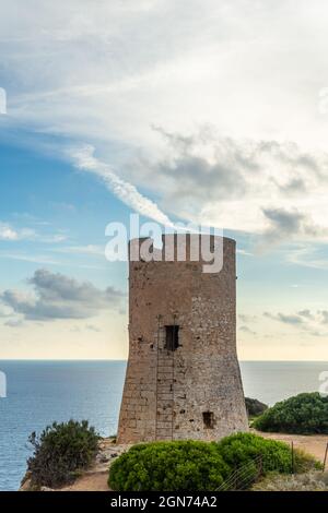 Ancient watchtower of Cap Blanc made of stone on the rocky coast of the island of Mallorca. In the background s seascape of the Mediterranean Sea at s Stock Photo