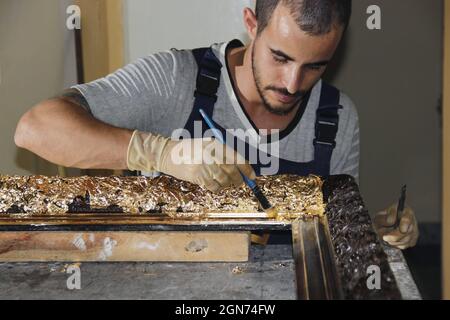 Hispanic young man crafting wood with tools Stock Photo