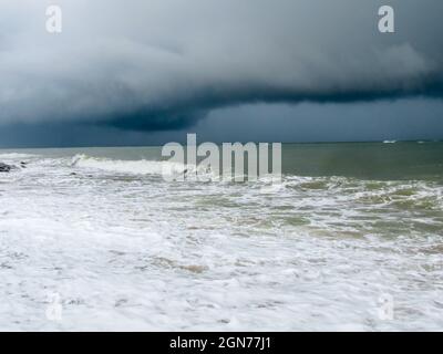 Dark rains and storm clouds forming over sea waters Stock Photo