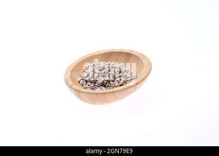 Shelled sunflower seeds on a wooden bowl against a white background. Food. Stock Photo