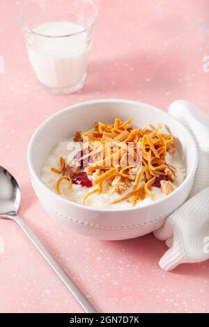 rice pudding with Norwegian brunost traditional brown cheese and raspberry jam Stock Photo