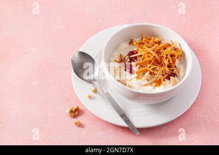 rice pudding with Norwegian brunost traditional brown cheese and raspberry jam Stock Photo