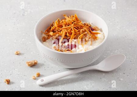 rice pudding with Norwegian brunost traditional brown cheese and raspberry jam Stock Photo