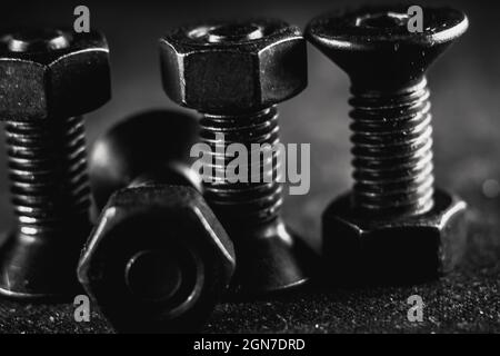 Grayscale shot of a pile of screws on a grunge background Stock Photo