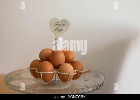 Fresh Eggs on a scale that stands on a wooden table with decoration at home Stock Photo