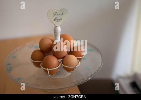 Fresh Eggs on a scale that stands on a wooden table with decoration at home Stock Photo
