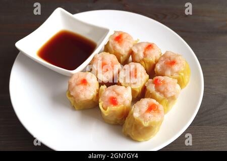 Tasty Shrimp and Pork Filled Chinese Steamed Dumplings Called Shumai on a White Plate Stock Photo