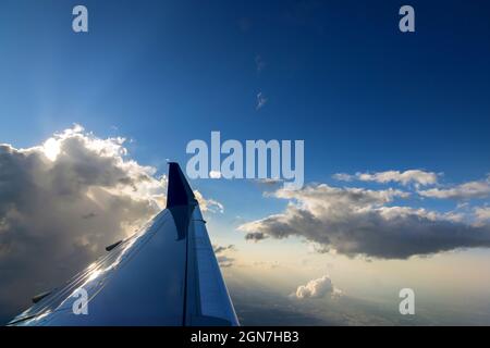 View of the airplane wing during a beautiful colorful cloudy sunset