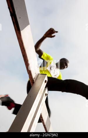 african american athlete jumping during obstacle race. low view Stock Photo