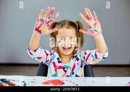 Premium Photo  Cute child sitting at the table and drawing red heart on white  paper, art school concept, girl kid painting with watercolor paints at home