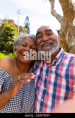Happy african american senior couple taking selfie and hugging Stock Photo