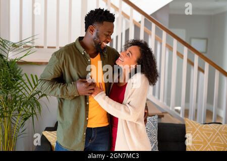 happy african american family hugging each other and laughing at home ...