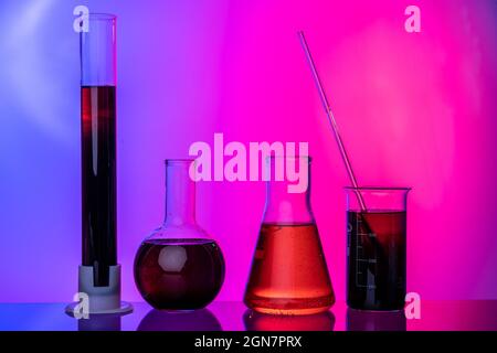 Laboratory glass tubes with chemicals on bright pink background Stock Photo