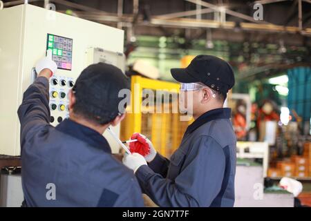 two engineer discussion about using technical robotic machine control panel Stock Photo