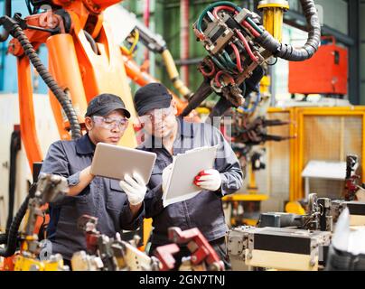 two employee checking production in tablet and notepad Stock Photo