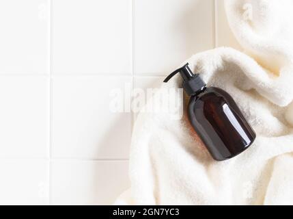 Brown bottle mockup for bathing products in bathroom, spa shampoo, shower gel, liquid soap on cotton towel flat lay. Top view. copy space Stock Photo