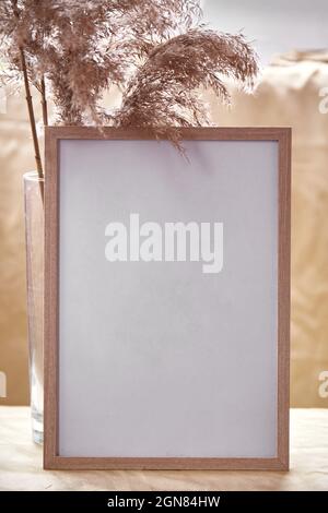 Minimalistic mock - up frame with dry flowers decorations. Cozy home atmosphere mockup. Natural beige background. High quality photo Stock Photo