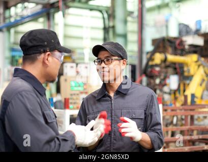 Two workers in a factory discussing how to work in factory Stock Photo