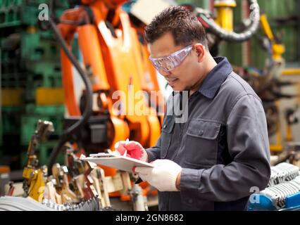 Industrial engineer writing on  notepad in factory Stock Photo