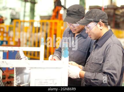 Two  workers discussing work in factory Stock Photo