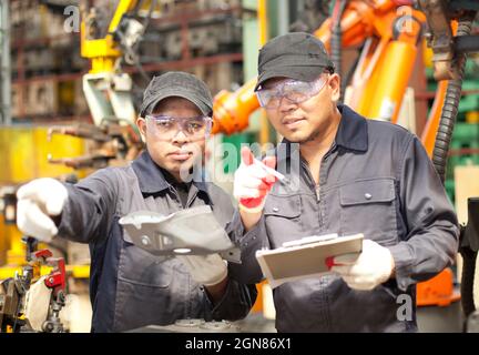 Two workers checking metal production Stock Photo