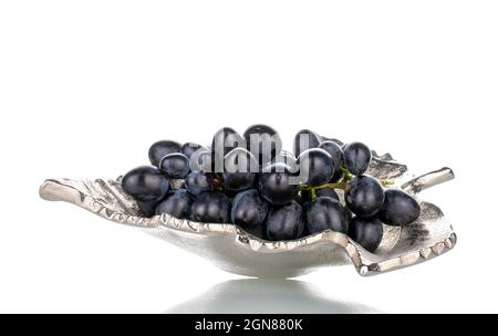 One bunch of sweet black grapes in a metal vase, close-up, isolated on white. Stock Photo