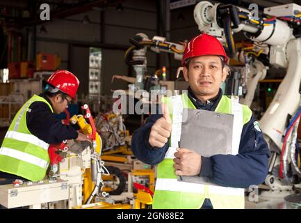 Foreman giving thumb up with operator on background Stock Photo