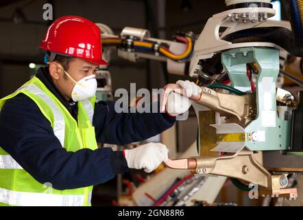 Industrial machine operator checking on robot machine Stock Photo