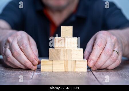 ten wooden blocks pyramid shaped blank template mock up with man in background Stock Photo