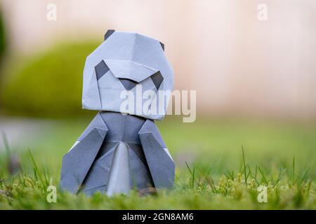Origami Panda  sat on natural  grass  outside in the park gardens Stock Photo