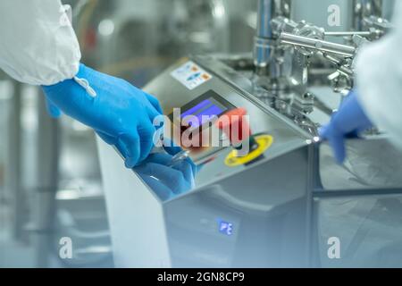 Closeup shot of medics working on a complex metallic machine with buttons and display Stock Photo