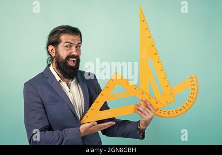 teacher of arithmetic with happy face holding protractor and triangle, learning stem. Stock Photo