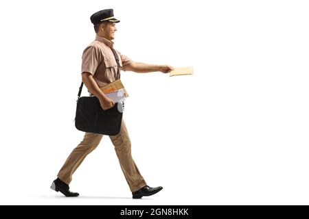 Full length profile shot of a mailman walking and delivering a letter isolated on white background Stock Photo