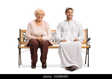 Young man in ethnic clothes and an elderly woman sitting on a bench and smiling isolated on white background Stock Photo