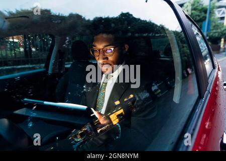 Young businessman using digital tablet while sitting in car Stock Photo