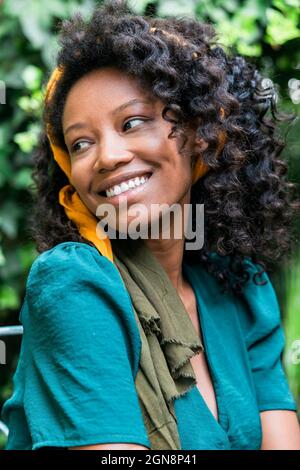 Smiling young woman with curly black hair Stock Photo