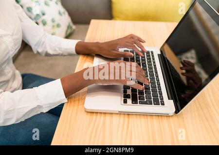 Female freelancer using laptop at table in cafe Stock Photo
