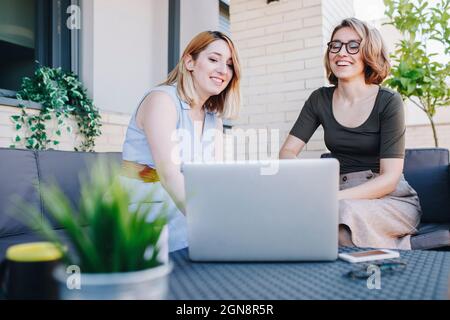 Businesswomen using laptop while sitting on sofa Stock Photo
