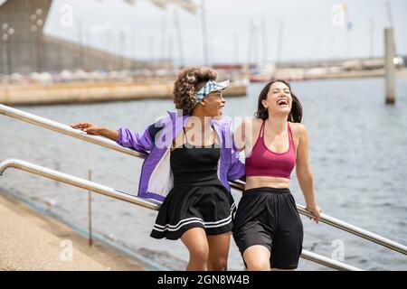Multi-ethnic female friends laughing while standing together Stock Photo