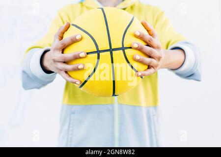 Young woman holding yellow basketball Stock Photo