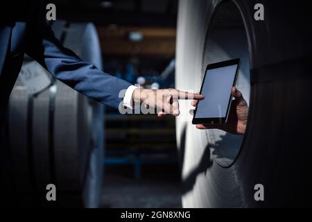 Businessman pointing at hand holding digital tablet Stock Photo