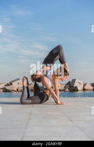 Young female friends doing acroyoga Stock Photo