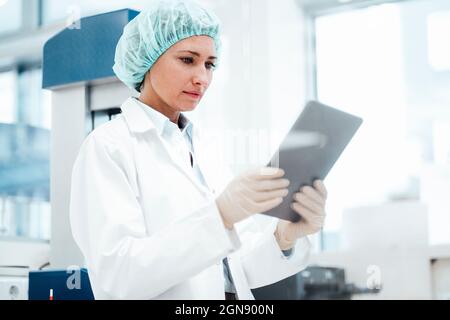 Female pharmacist using digital tablet at medical store Stock Photo