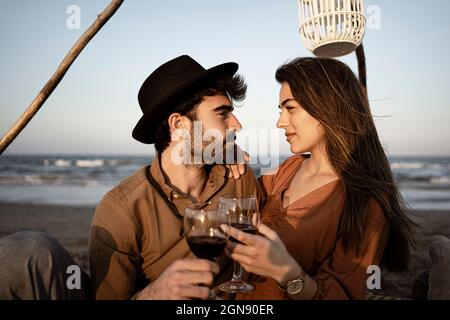 Couple looking at each other while holding drinks during picnic Stock Photo